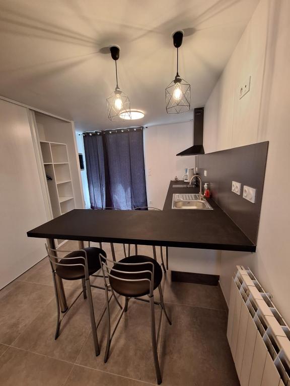 a kitchen with a table and chairs in a room at La Campanule in Saint-Cyr-en-Pail