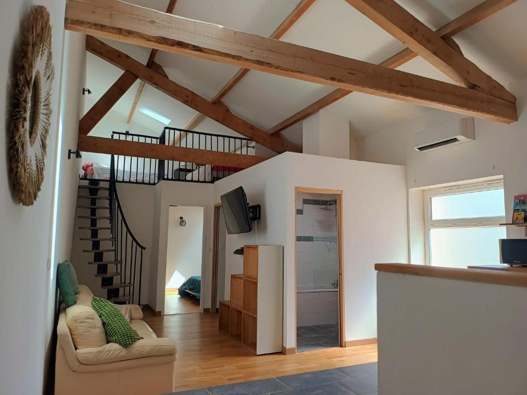 a living room with a vaulted ceiling with wooden beams at Chez Audrey in Courthézon