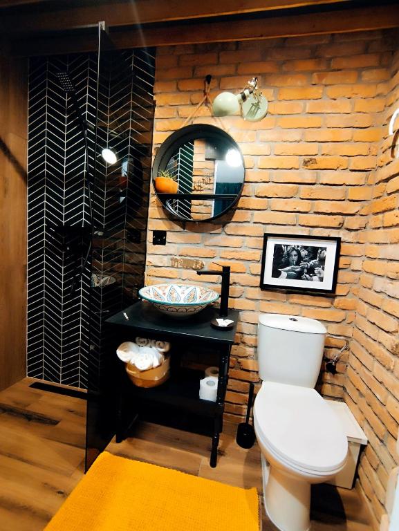 a bathroom with a toilet and a wooden wall at Casa FaRa in Vama Veche