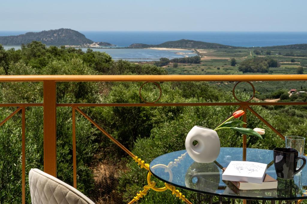 a table on a balcony with a view of the ocean at Anima Horizon - Thea apartment in Elaiófiton
