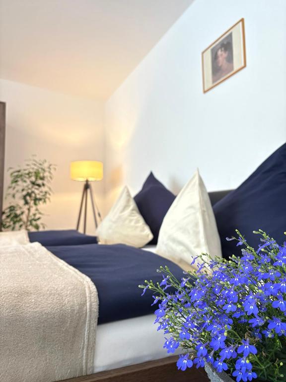 a living room with a couch and blue flowers at Gartenstudio Anila in Cochem