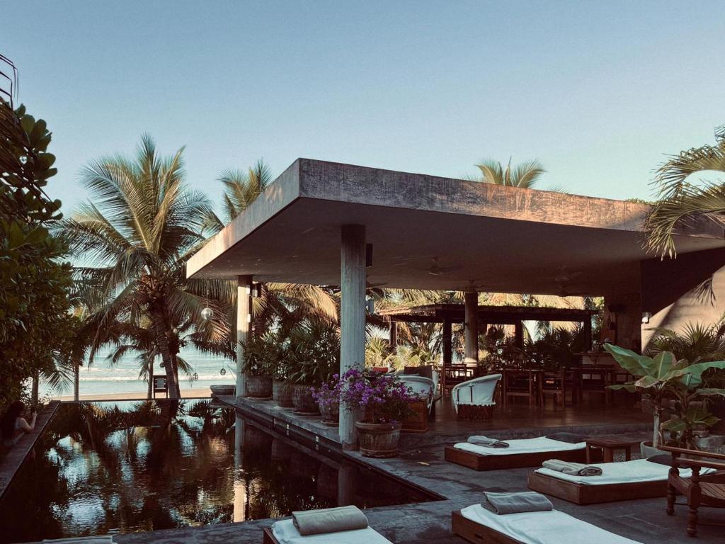 ein Resort mit Swimmingpool und Palmen in der Unterkunft Lo Sereno Casa de Playa in Troncones