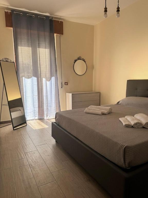 a bedroom with a bed and a mirror and a window at Mimmo Wanderlust in Mazzeo