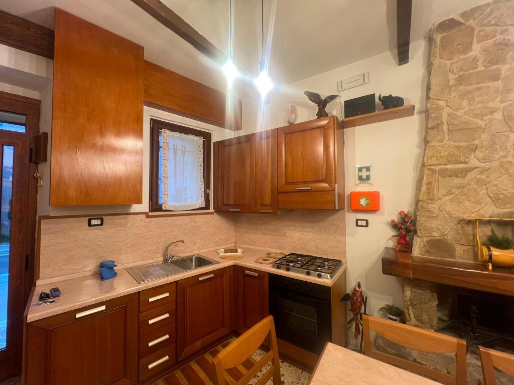 a kitchen with wooden cabinets and a stove top oven at Sangro River Casa Vacanza in Castel di Sangro