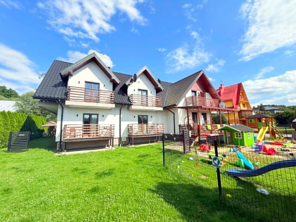 a house with a playground in the yard at Willa Kamilówka in Rabka-Zdrój