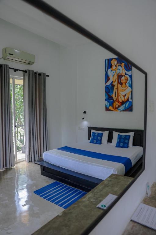 a bedroom with a king sized bed and a mirror at Everdew Kandy Rooms in Kandy