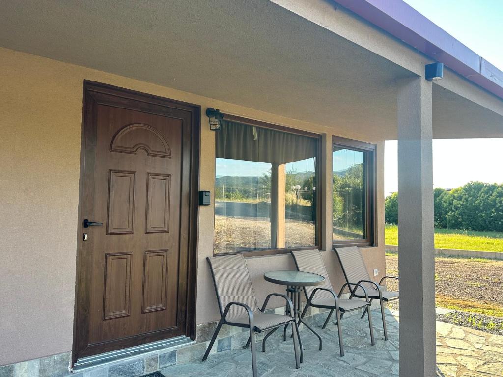a porch with chairs and a door and a table at Letsios Steel3 in Kalabaka