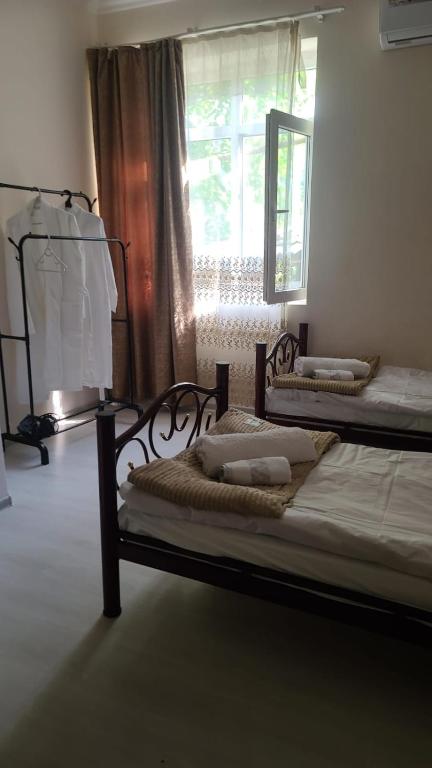two beds in a room with a window at Oni Guesthouse in Oni