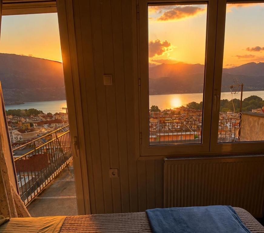 a room with a window with a view of the sunset at Skyline apartment Ioannina in Ioannina