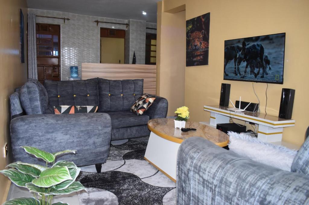 a living room with two couches and a table at Unique Place 1 Bedroom Thika in Thika