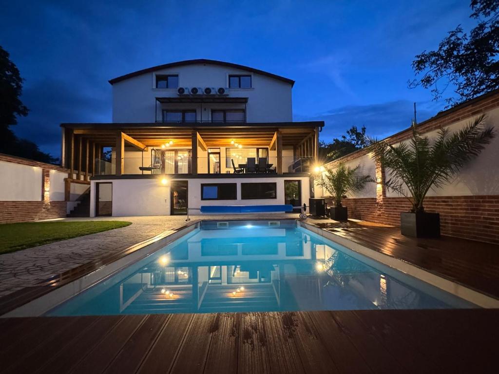 a house with a swimming pool in front of a house at Casa DAVIANA in Luna de Sus