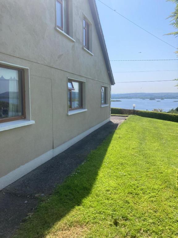 a house with a grassy yard next to a building at Islandview House in Clonbur