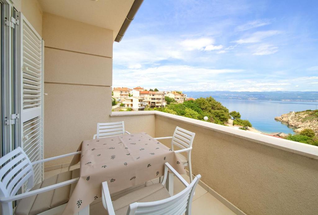 a balcony with a table and chairs and a view of the water at Apartman Pina in Vrbnik