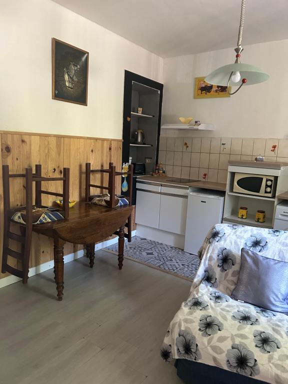 a kitchen with a table and a couch in a room at Au bonheur de LILI in Fontaine-de-Vaucluse