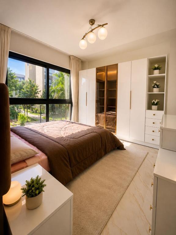 a bedroom with a large bed and a large window at Stunning view in Madinaty in Madinaty