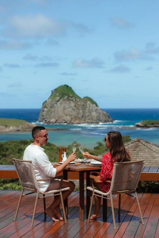 Casal brindando com vista para a Baía do Sueste — Restaurante Maravilha