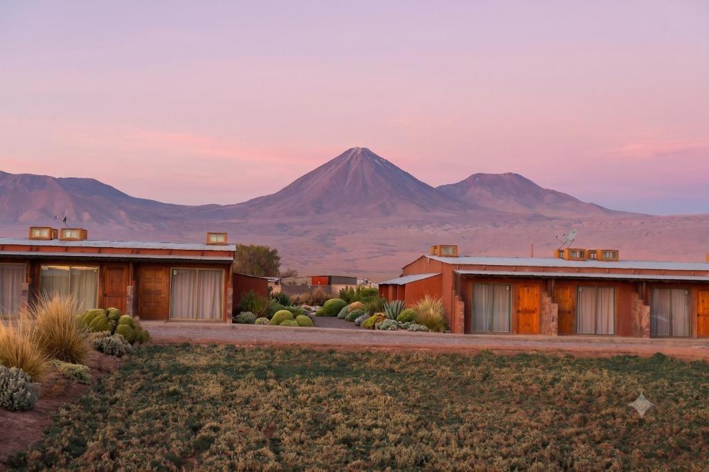 a house in the desert with a mountain in the background at Eltoconar atacama in San Pedro de Atacama