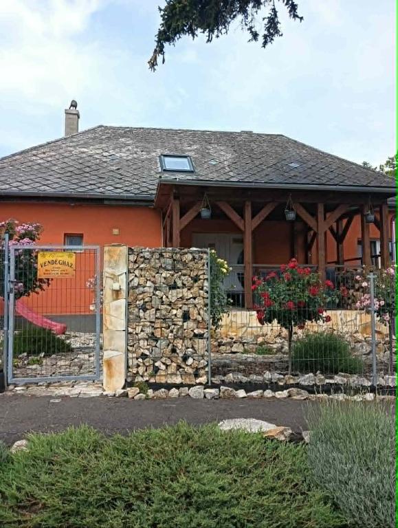 a house with a stone fence in front of it at Rózsa vendégház in Zirc