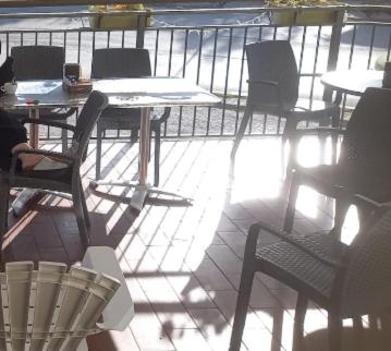 a patio with tables and chairs on a balcony at La Voglia in Villanova sullʼArda