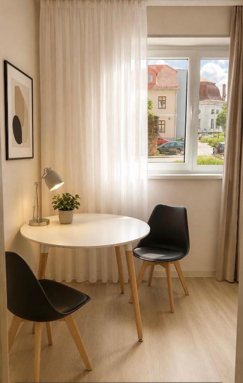 a table and chairs in a room with a window at Modi Line Vee in Valga