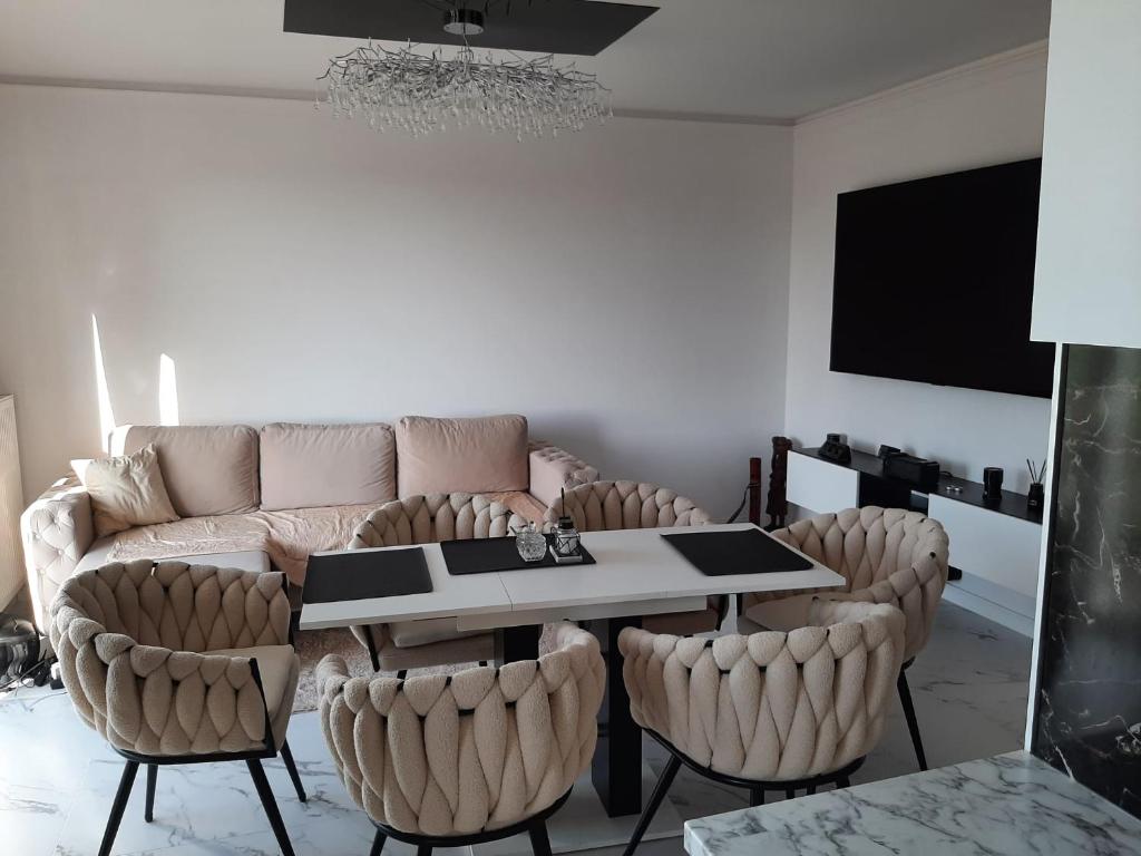 a living room with a couch and a table and chairs at ApartamentyDiana in Pogórze