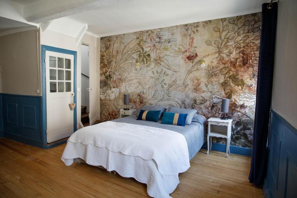a bedroom with a large bed and a wall mural at L' Accointance in Semur-en-Auxois