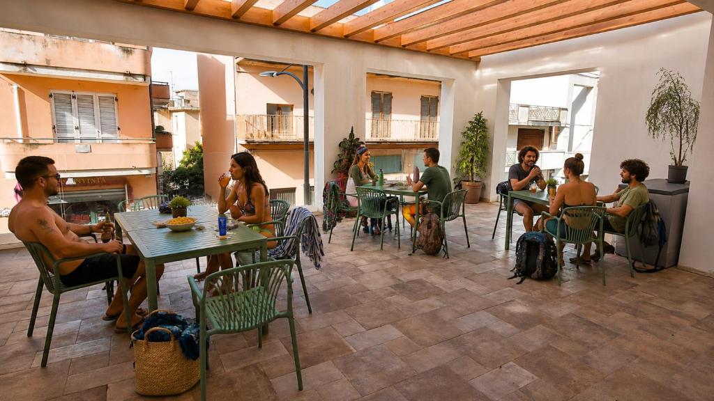a group of people sitting at tables in a patio at Central Dorgali Guest House in Dorgali