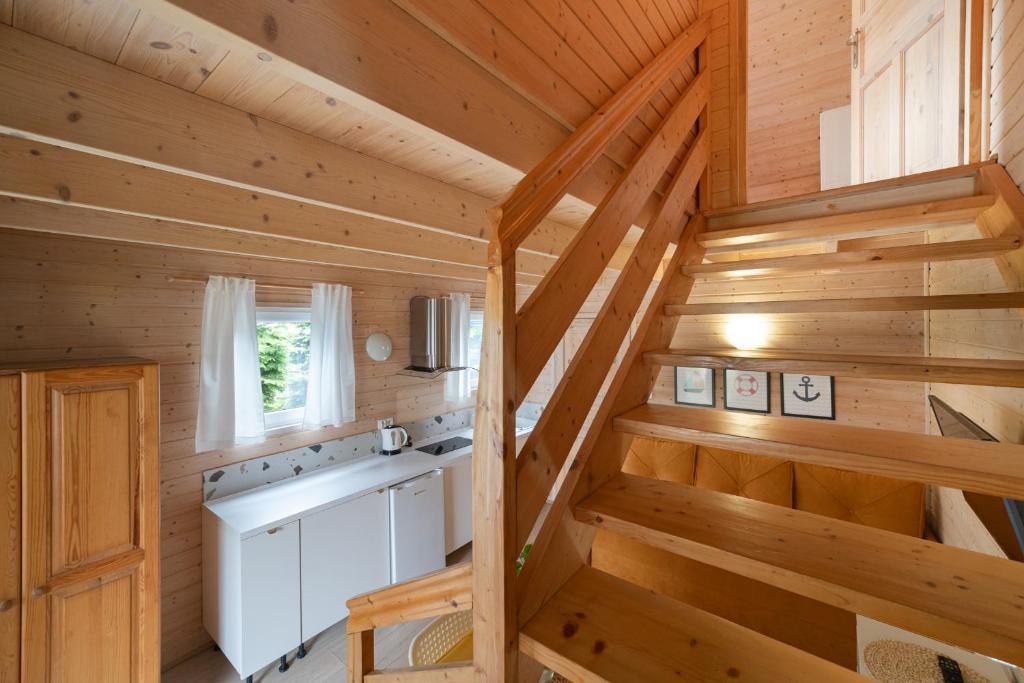 a kitchen in a log cabin with wooden stairs at Domki Błękitne Nad Morzem Międzywodzie in Międzywodzie