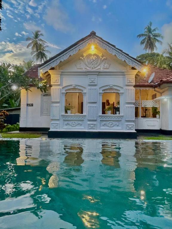 a white house with water in front of it at Casa Del Ceylon in Hikkaduwa
