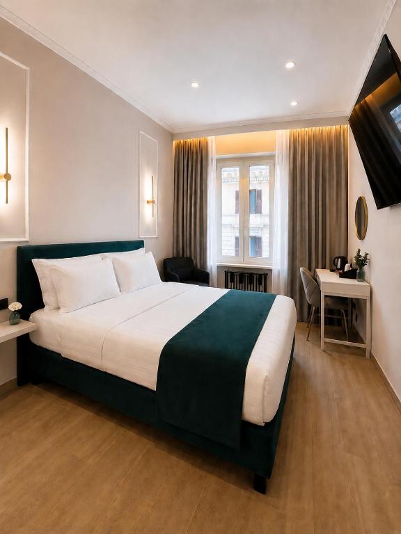 a hotel room with a large bed and a desk at Ciao Termini in Rome