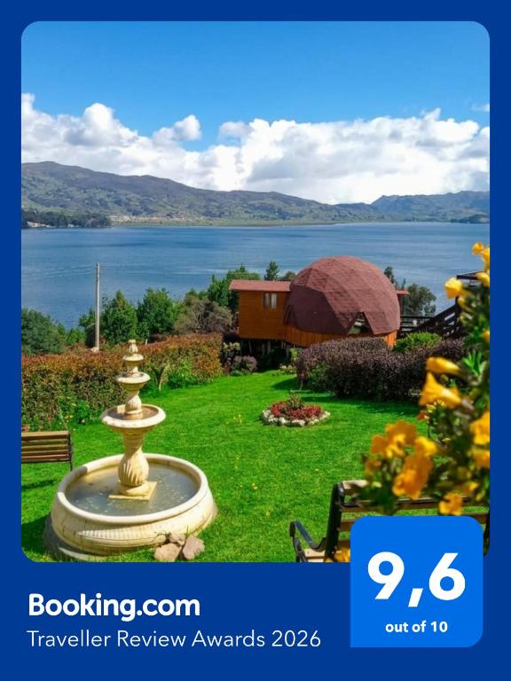 a fountain in a yard with a view of a lake at Domos Lago Muisca Chia in Aquitania