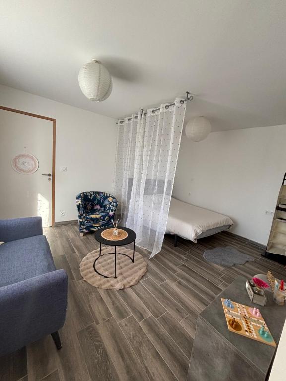 a living room with a couch and a table at Appart Résidence Yadah RDC in Granville
