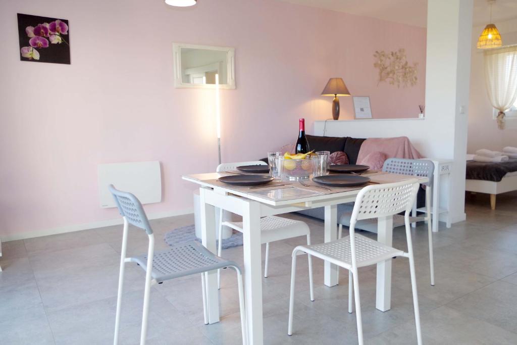 a white table and chairs in a living room at Grand studio La Sensée - Parking privé, Terrasse, Netflix, au calme in Hem-Lenglet