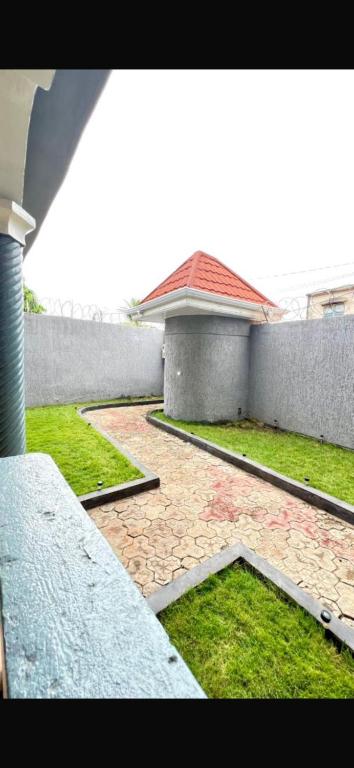 a view of a courtyard with a building and grass at Rach in Komé