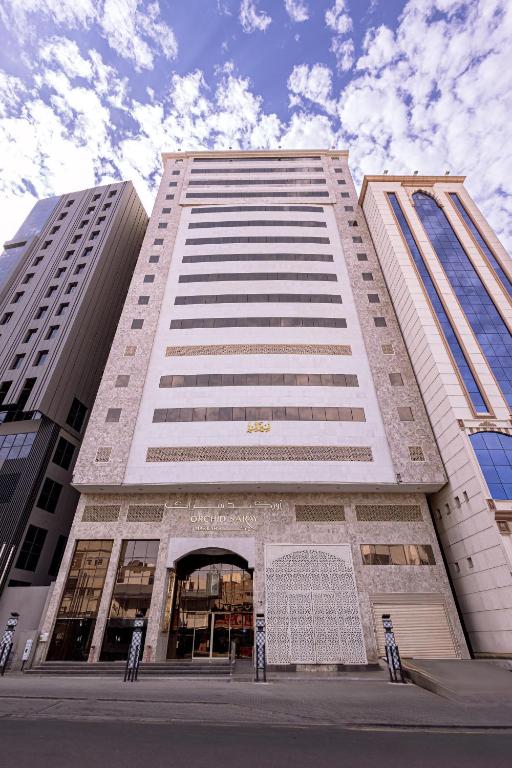 a tall white building with a gate in front of it at فندق أوركيد مكة in Mecca