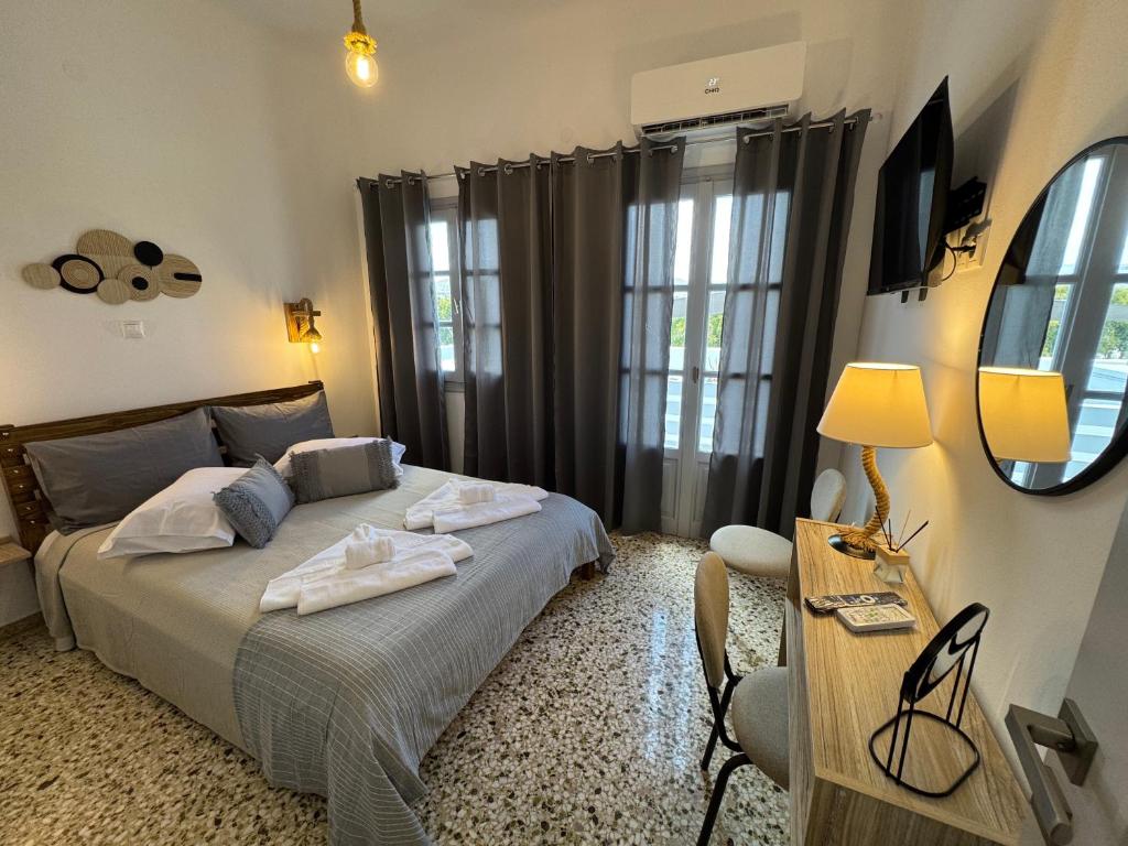 a bedroom with a bed and a desk and a mirror at Naousa Nest in Naousa