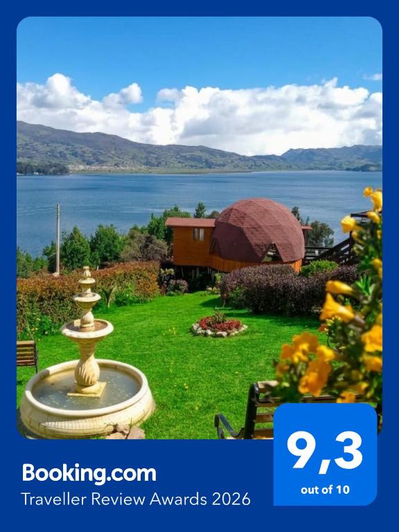 a fountain in a yard with a view of a lake at Domos lago Muisca Xue in Aquitania