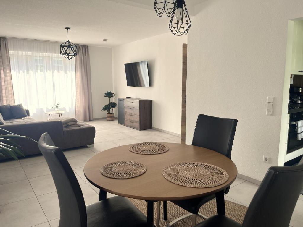 a living room with a wooden table and chairs at Rheiner WohlfühlSuite mit Garten in Rheine