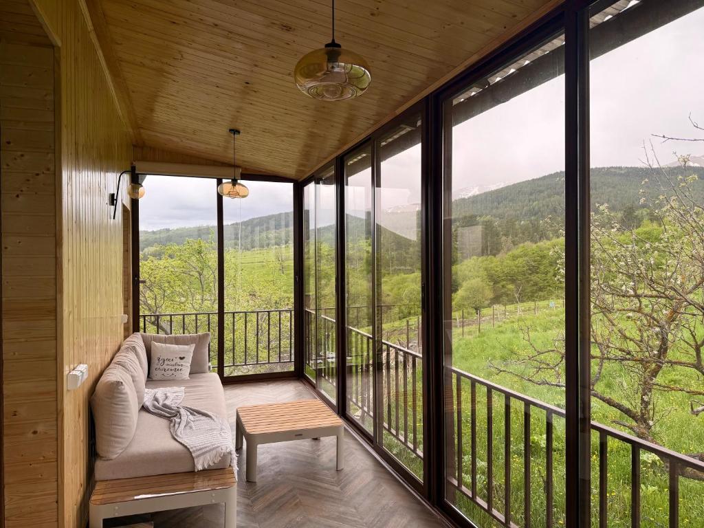 eine überdachte Veranda mit einem Stuhl und einem Tisch in der Unterkunft Tesaran Stepanavan Guest House, Apart Hotel in Stepanawan