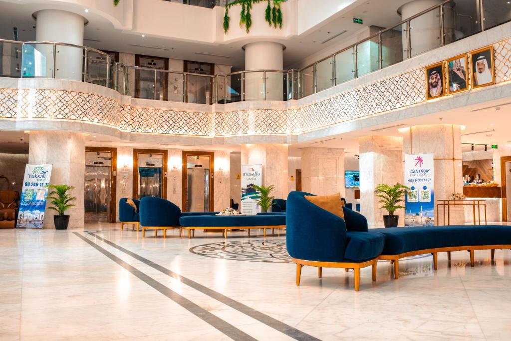 a lobby with blue chairs and tables in a mall at فندق الكنارى ان in Mecca