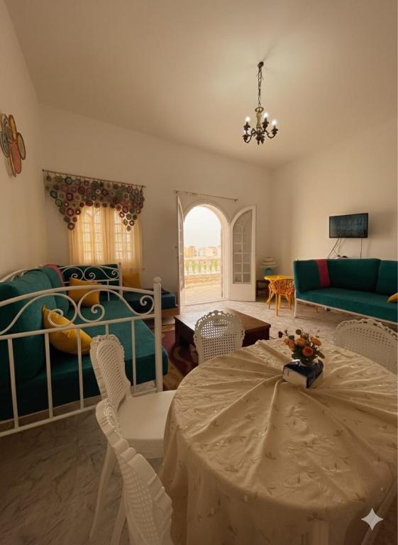 a living room with a table and chairs and a couch at Dina Mansour's vacation home 54 A upper in Dawwār ‘Abd Allāh