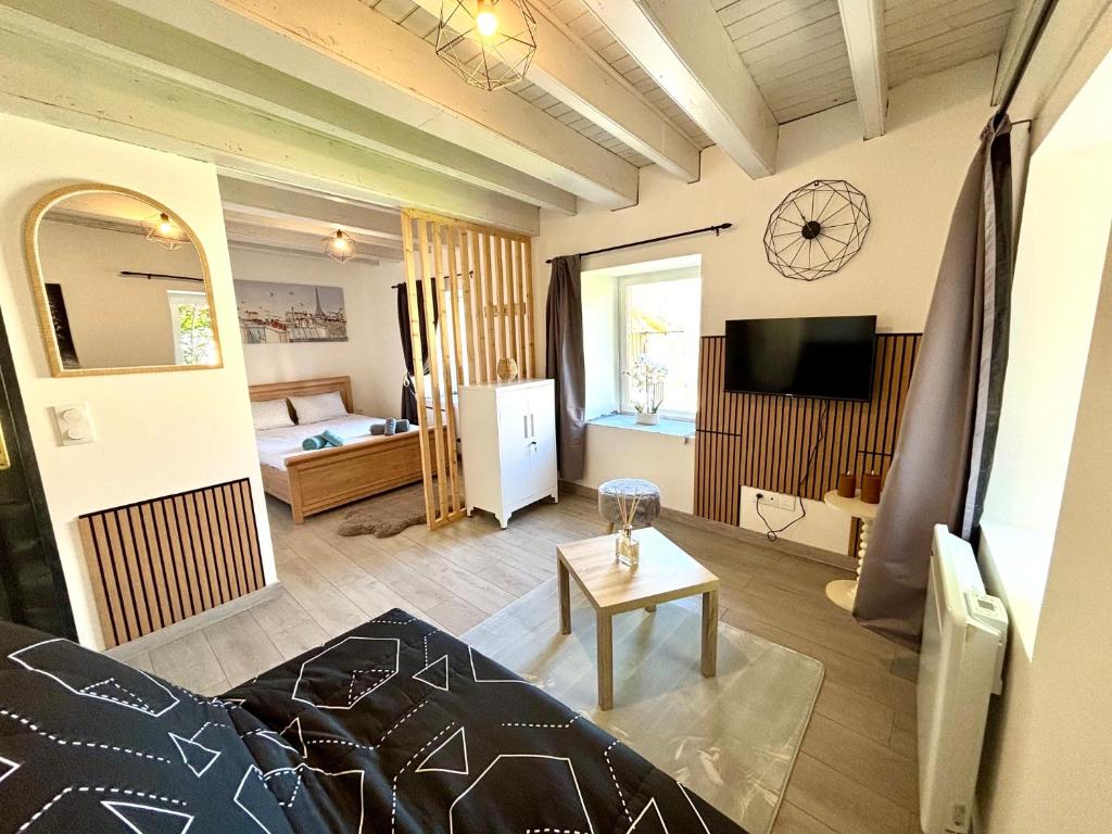 a living room with a couch and a television at Escapade en Auvergne - centre historique - 3 personnes in Olliergues