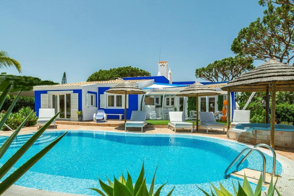 a villa with a swimming pool and a house at Villa CHELSEA in Vilamoura