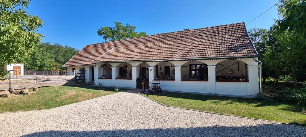 a small white building with a brown roof at Age Gone By Guesthouse in Kemenesmihályfa