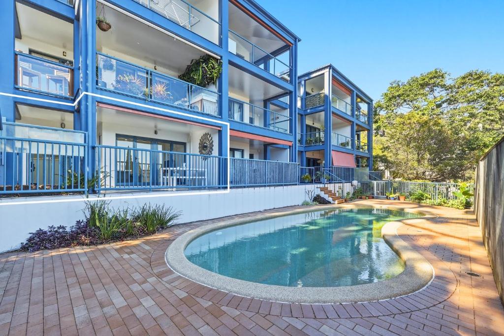 an apartment building with a swimming pool in front of a building at Poolside 2-Bed Apartment Near Coolangatta in Gold Coast