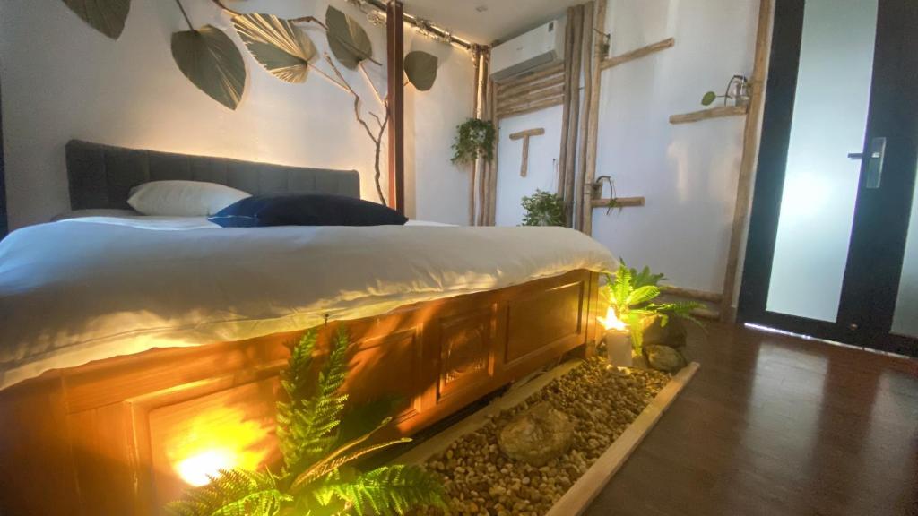 a bedroom with a bed with a fish tank next to it at T - Bona Homestay in Xã Thang Tam