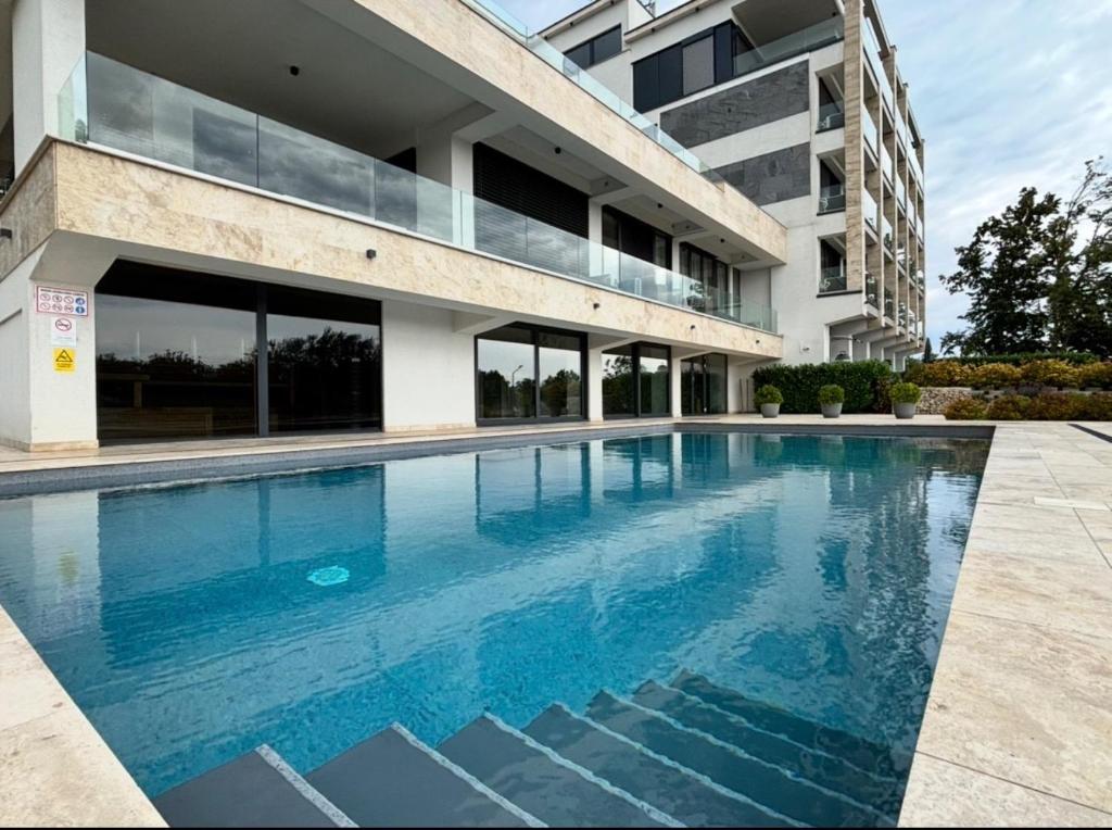 a swimming pool in front of a building at Andrea Apartman in Alsóörs