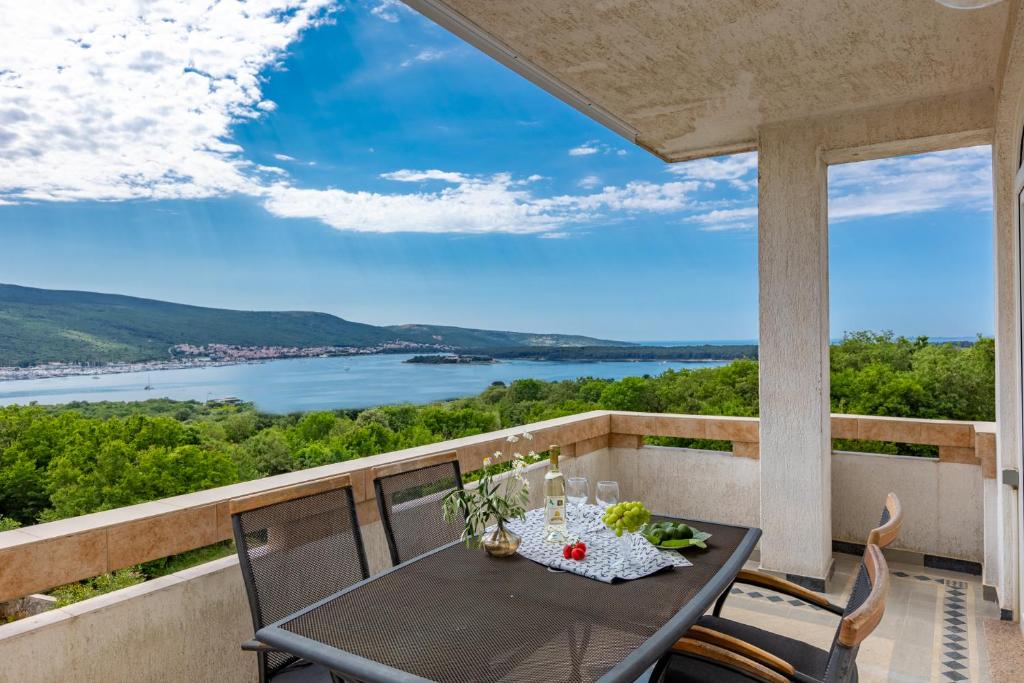 a table on a balcony with a view of the water at Apartman Izi Green s pogledom na more in Kornić