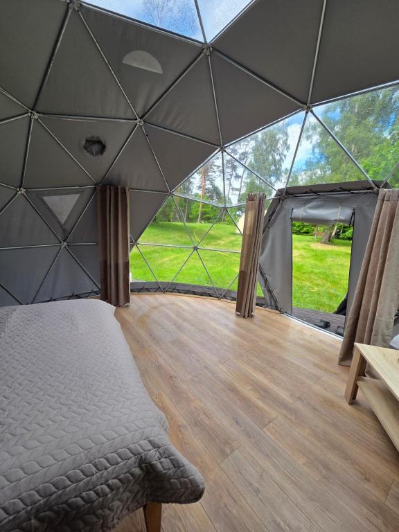 a room with a bed inside of a tent at Spranču Glempings in Bernāti