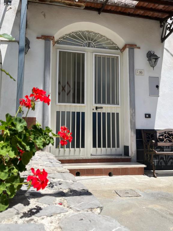 a front door of a house with red flowers at Antica Casa Cavaliere in Tramonti